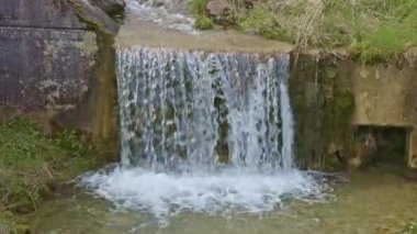 Şelaleden dökülen su, yakın çekim görüntüsü. Nehirdeki taşların etrafında su akıyor. Beckenried yakınlarındaki Traeschlibach, Canton Nidwalden, İsviçre.