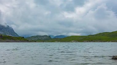 Zaman atlaması, dağlarla çevrili bir göl manzarası. Glattalpsee Gölü, Glattalp, Muotathal, Schwyz Kantonu, İsviçre.