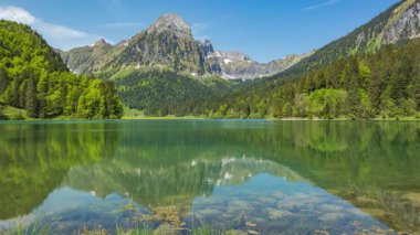 Zaman atlaması, dağlarla çevrili bir göl manzarası. Obersee Gölü, Canton Glarus, İsviçre.