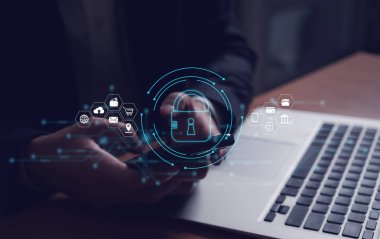 Erkekler internet bağlantısı olan bilgisayar dizüstünü kullanırken kilit simgesini tutuyorlar. Virüs, siber suç ve gizlilik ve bilgiye yönelik dijital tehditleri önlemek için siber güvenlik koruması.