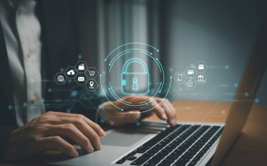Erkekler internet bağlantısı olan bilgisayar dizüstünü kullanırken kilit simgesini tutuyorlar. Virüs, siber suç ve gizlilik ve bilgiye yönelik dijital tehditleri önlemek için siber güvenlik koruması.