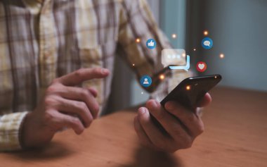 Çevrimiçi sosyal medya platformunda arkadaşınla sohbet ve iletişim kurarken akıllı telefondan erkeklerin eline odaklan. İnsanların fotoğraf ve içeriği paylaşabileceği ya da yükleyebileceği sanal topluluk.