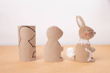 Geri dönüştürülmüş kağıt tüpten yapılmış bir Paskalya tavşanı, DIY, özel ders, çocuklar için el işi, beyaz arka plan.