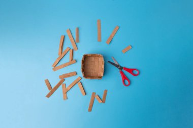 Geri dönüştürülmüş kağıt torbadan yapılmış sepet, DIY, adım adım talimatlar, makasla örülmüş ve kesilmiş kağıt şeritler, üst görünüm