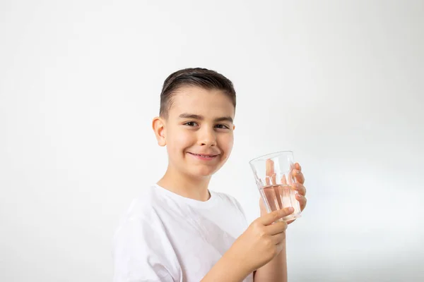 Chłopiec Trzyma Szklankę Wody Uśmiechnięty Białe Tło — Zdjęcie stockowe