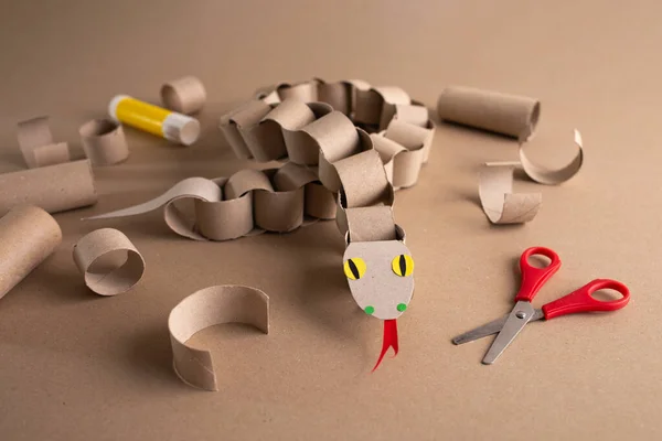 Tuvalet kağıdı rulolarından bir yılan, geri dönüşüm kartonu, DIY, özel ders, çocuklar için eğitim sanatı, kağıt zincirli piton oyuncağı