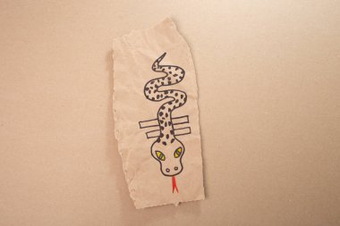 Boş, şablon ya da geri dönüşümlü kağıttan yapılmış bir yılan ya da ejderha sanatı, DIY, özel eğitim sanatı ve çocuklar için el işi, üst görünüm, çocuklar için çizimler