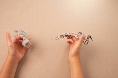 Geri dönüştürülmüş kağıttan yapılmış parmak yılanı ya da ejderha zanaatı, DIY, özel ders, çocuklara yönelik eğitim sanatı ve el işi, üst görünüm