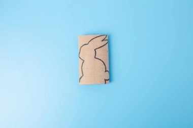 Çocuk ve anaokulu, spor salonu, özel ders, bahar oyuncağı, geri dönüşüm sanatı, tavşan şablonu için tuvalet kağıdı konsepti. Üst görünüm, mavi arkaplan