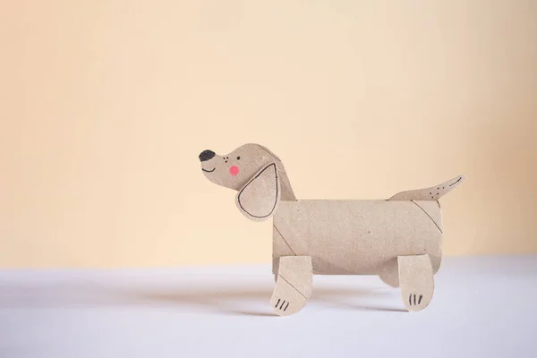 a dog made out of toilet paper roll, cut out of cardboard, dachshund, kids toy, recycled paper craft concept, DIY, activity for kids
