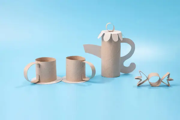 stock image Colorless paper craft, teapot and cups for a doll tea party, embodying recycling concepts. Ideal for DIY crafting with kids.