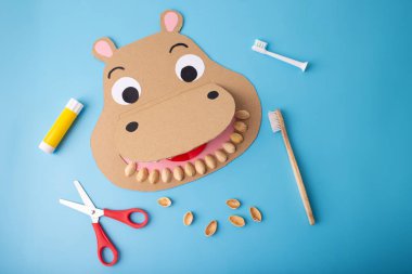 Creative paper craft shaped like a hippo with a toothbrush puppet, ideal for kids, made from cardboard. clipart