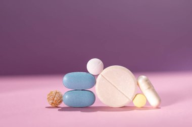 Masanın üstünde duran birkaç hap, figür libre tarzı, mavi ve pembe renk şeması. İlaç, sağlık ve eczacılık konularında modern sanatsal çarpıklığa sahip konular için ideal..