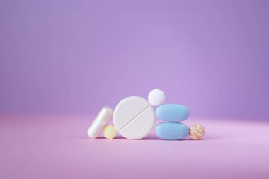 Düz yüzeyde düz mor arka planda hap ve tablet koleksiyonu. Çeşitli boyut ve renkler, ilaçlar, sağlık hizmetleri, ilaçlar için uygun..