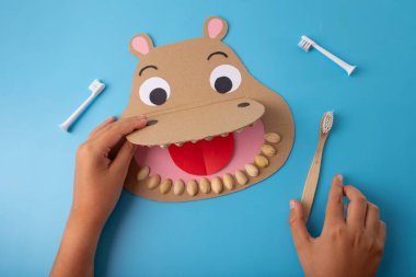 İlköğretim için yaratıcı DIY zanaatı: kağıt yapımı su aygırı kafası geniş ağzı, fıstık, mukavva, diş fırçası, çocuklara diş ve diş sağlığını öğretmek, eğlenceli eğitim projesi.