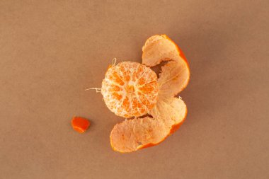 Bej bir yüzey üzerinde soyulmuş bir mandalina, minimalizm, üst görünüm