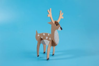 Geyik kağıdı model düz arka plan, geri dönüşüm konsepti, el sanatları meraklıları ve hayvan modeli projeleri için ideal.