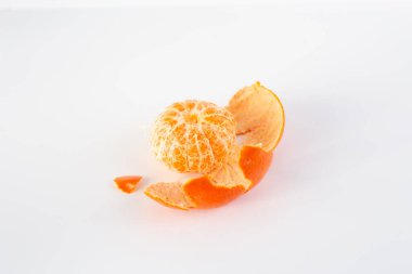 Beyaz bir yüzeyin üzerinde soyulmuş bir mandalina, minimalizm, üst görünüm