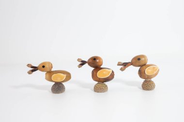 Doğal detayları olan palamutlardan yapılmış bir sıra ördek. Yaratıcı sonbahar zanaatı, sonbahar temalı dekor için mükemmel 