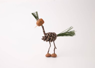 Doğal malzemelerden yapılmış yaratıcı kuş heykeli, çam kozalağı gövdesi, meşe palamudu başı, çam iğnesi tüyleri, dal bacaklar, tohum gözleri. Doğa esinlenilmiş zanaat, mevsimlik dekorasyon ve eğitim projeleri için mükemmel.