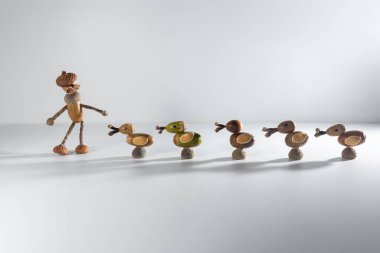 Five handmade ducks made from acorns and twigs, aligned in a row. Unique nature art with one green and four brown ducks. Ideal for autumn decor, eco friendly crafts, and DIY inspiration. clipart