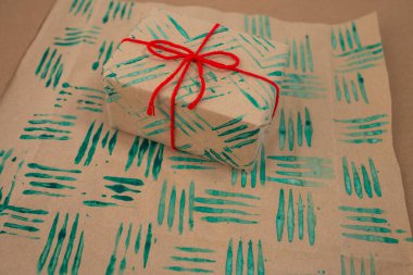 Dekoratif pullar özel ambalaj kağıdı yapmak için çatal ve boya kullanılıyor. Kişisel tasarımlar için kağıt üzerinde DIY el işi projesi. Çocuklar için eğlenceli Noel aktivitesi, yaratıcı tatil projesi