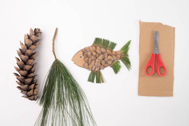 Doğal malzemelerden yapılmış balığa benzeyen yaratıcı bir sanat eseri. Açık havada anaokulu eğitimi, ders imajı, çocuklar için yaratıcı sanat projesi etkinliği