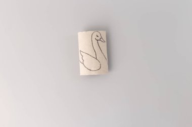 Tuvalet kağıdı rulolarından bir kuğu nasıl yapılır, sanat eseri, minyatür oyuncak, yaratıcılığa adım at, DIY, yukarıdan aşağıya görüş, gri arka plan