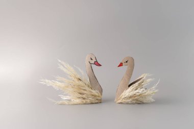 couple of swans, funny characters made by child from nature materials and recycled paper roll, autumn craft for preschoolers clipart