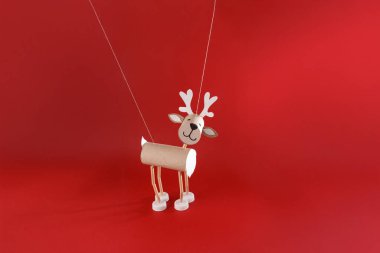 Çeşitli malzemelerden yapılmış el yapımı bir ren geyiği gemisi. Vücut, karton tüplü tuvalet kağıdı rulosundan yapılmıştır. Bacaklar pipetten yapılır, beyaz plastik şişe kapakları toynak görevi görür.. 