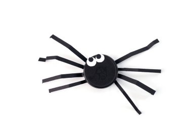 ideas for a class recycling plastic caps tutorial, Black plastic bottle cap transformed into spider with paper legs on a white. Minimalist flat lay composition, DIY summer craft for kids, homemade clipart