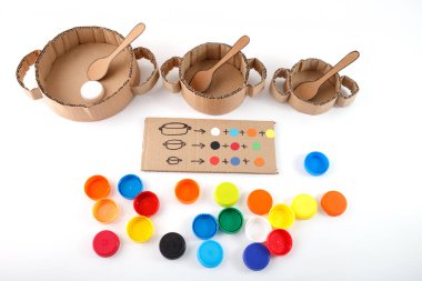 Renkli kapaklı karton kaplar, eğitim sıralama aktivitesi, çocukların renkleri öğrenmesi, DIY el işi projesi, sürdürülebilir malzemeler, eğitim araçları, renk sıralama oyunu, çevre dostu el sanatları