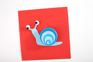 Plastik kaplama ve kağıt malzemeden yapılmış kabuklu salyangoz. Çocuklar için sanat projesi, çocuklarla oynamak, renkli şapkalı fikirler, komik el yapımı etkinlik, geri dönüşüm materyali, anaokulu saati 