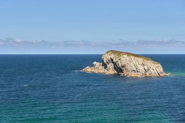 Big island in the middle of the ocean on sunny day Clouds, lonely, calm sea, vegetation