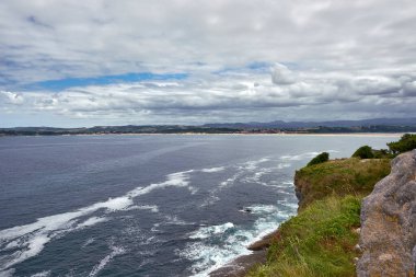 Santander Bay, Spain, on a cloudy day.Still water, foreground with vegetation, sand storm