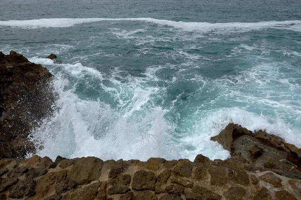 波が砂利道で海岸に速報 水の泡野生の水の質感海岩危険 — ストック写真