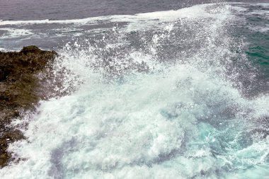Çakıl taşlı bir yolda dalgalar kıyıya vuruyor. Su köpüğü, vahşi sular, doku, okyanus, deniz, kayalar, tehlike