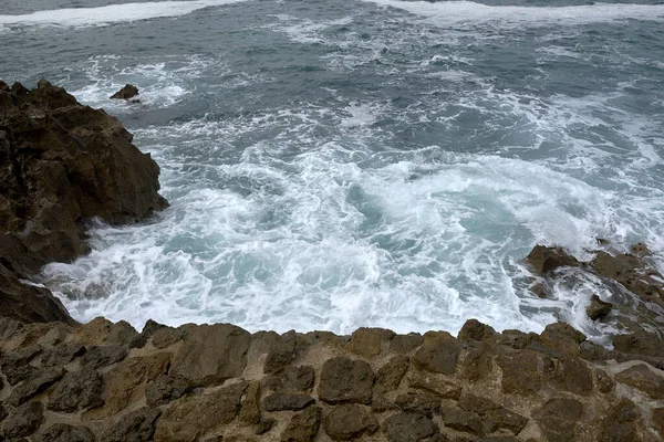 波が砂利道で海岸に速報 水の泡野生の水の質感海岩危険 — ストック写真