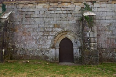 Lierganes, İspanya 'daki San Pantaleon Kilisesi' nin kapısı. Romanesque, Cantabria, Taş Duvarlar, metal kapı, bitki örtüsü.
