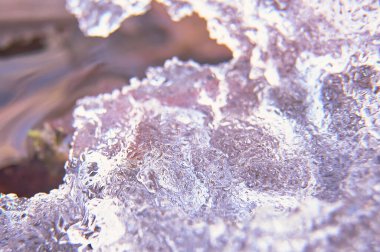 Buz bloklarının ayrıntıları, dağ deresinin üzerinde. Bulanık arkaplan, makro fotoğrafçılık, su, kış, soğuk, buz, doku, zenital görünüm