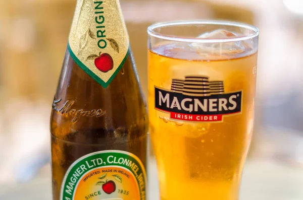 stock image FUENGIROLA, SPAIN - OCTOBER 10, 2021: Bottle of Magners Irish Cider, served chilled in a Magners logo glass