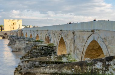CORDOBA, İSPAN - 14 Şubat 2014: İspanya 'nın Endülüs kenti Cordoba' daki antik Roma taş köprüsünü geçen insanlar