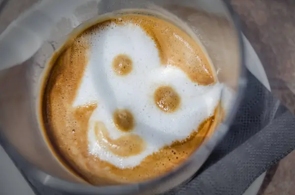 Coffee decorated with a smiley face figure made of milk foam