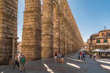 SEGOVIA, İspanya - 14 Ağustos 2022: Segovia, Kastilya ve Leon, İspanya 'nın simgesi olan ünlü Roma su kemerini ziyaret eden turistler