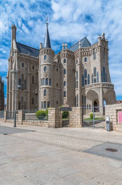 ASTORGA, İspanya - 20 AĞUSTOS 2022: İspanya 'nın Kastilya ve Leon Piskoposluk Sarayı' nın neo-gotik binasının manzarası. 1889 ve 1915 yılları arasında inşa edilmiş modernist mimar Antoni Gaudi tarafından tasarlanmıştır.