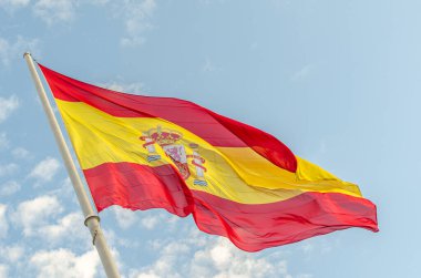 Bulutlu mavi arka planda rüzgarda dalgalanan İspanyol bayrağı