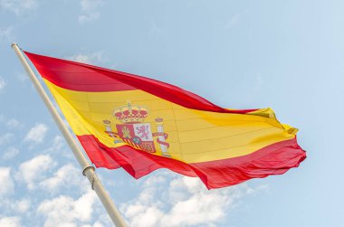 Bulutlu mavi arka planda rüzgarda dalgalanan İspanyol bayrağı