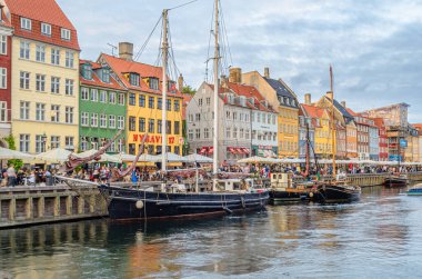 COPENHAGEN, DENMARK - 7 Temmuz 2014: Danimarka 'nın Kopenhag kentindeki 17. yüzyıl rıhtım, kanal ve eğlence bölgesi Nyhavn' daki renkli evler, barlar, restoranlar ve turistlerin manzarası