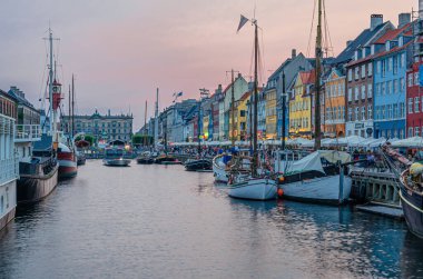 COPENHAGEN, DENMARK - 8 Temmuz 2014: Danimarka 'nın Kopenhag kentindeki 17. yüzyıl rıhtım, kanal ve eğlence bölgesi Nyhavn' daki renkli evler, barlar, restoranlar ve turistlerin manzarası