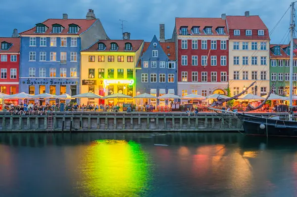 COPENHAGEN, DENMARK - 8 Temmuz 2014: Danimarka 'nın Kopenhag kentindeki 17. yüzyıl rıhtım, kanal ve eğlence bölgesi Nyhavn' daki renkli evler, barlar ve restoranların alacakaranlıkta görülmesi